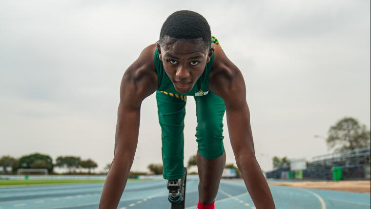 Young man with prosthetic leg getting ready to sprint