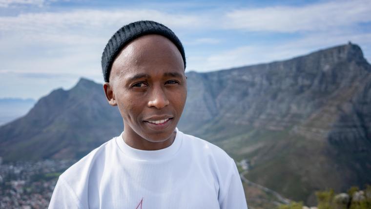 Beautiful News - Sakhiwo Ndawose of Blazing Pens Cypher Hikes stands with Table Mountain behind him