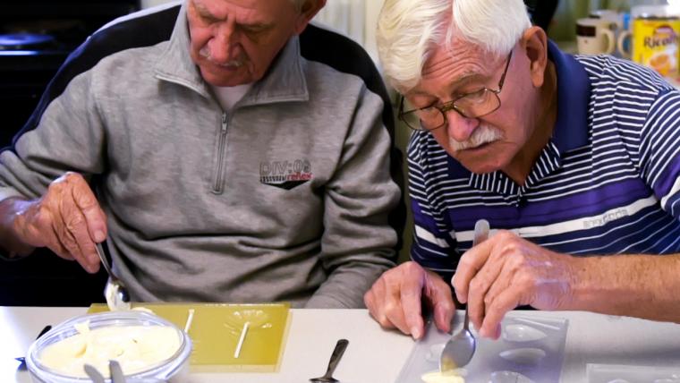Two elderly men making chocolate