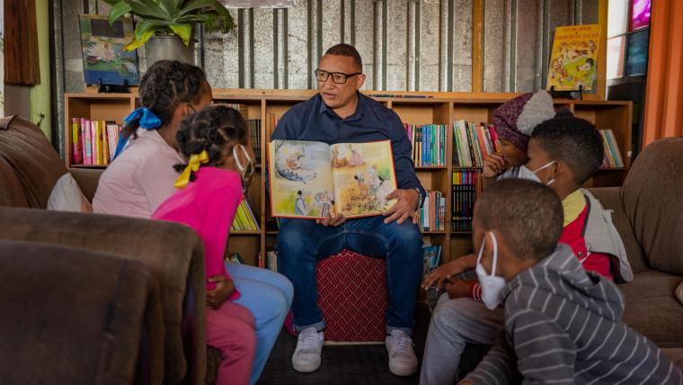 Beautiful News - Terence Crowster of Hot-Spot Library reading a children's book to a group of interested youngsters