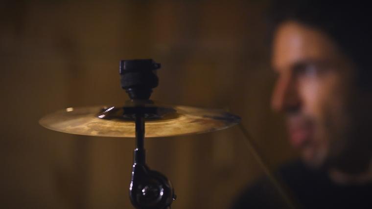 Cymbal with a blind drummer behind it.