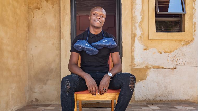 Black man sitting on chair on porch.