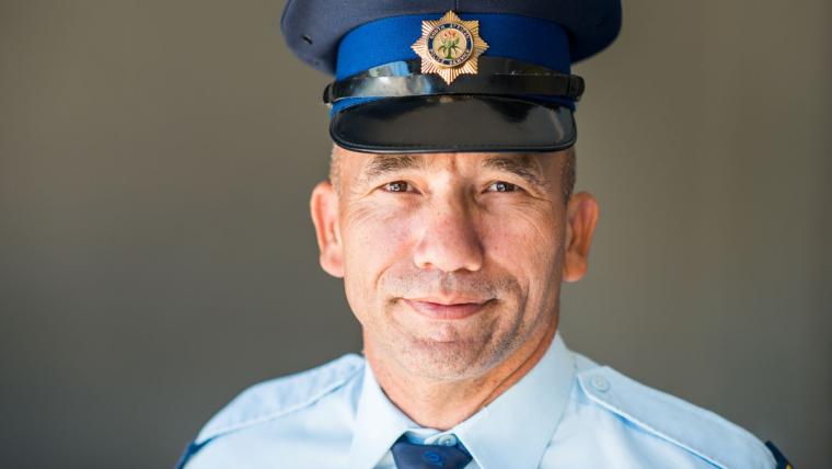 Officer smiling into camera.