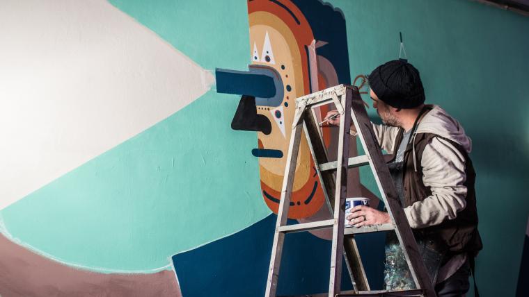 Graffiti artist painting on a wall