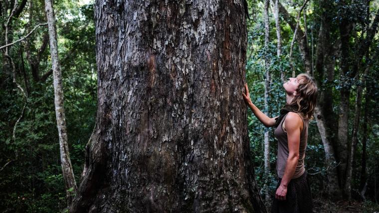 Woman standing next to a tree