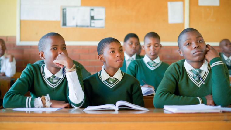 Boys in school uniform sit in a classroom