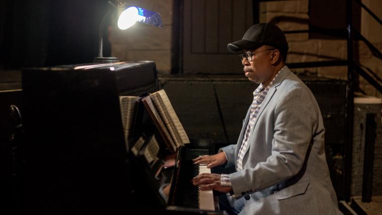 Black musician playing the piano.