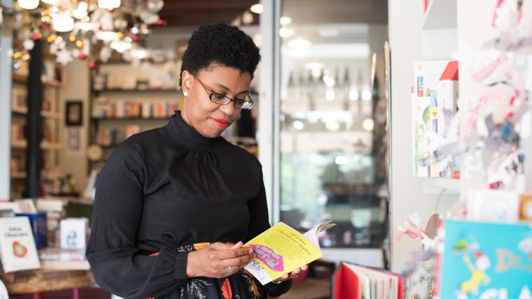 Black author standing with her book.